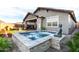 Beautiful backyard featuring a pool, covered patio, firepit, and lush landscaping at 13384 W Red Range Way, Peoria, AZ 85383