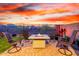 Cozy backyard patio with an outdoor firepit, seating, and desert views at 13384 W Red Range Way, Peoria, AZ 85383