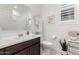 Bright bathroom featuring a dark vanity, white toilet, decorative accents, and a shower with a white shower curtain at 13384 W Red Range Way, Peoria, AZ 85383
