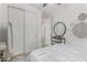 Bedroom with white walls, carpeted floor, closet with sliding doors, and a decorative mirror over a small cabinet at 13384 W Red Range Way, Peoria, AZ 85383