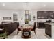 Charming dining area with a dark wood table, modern lighting, and seamless flow into the living area at 13384 W Red Range Way, Peoria, AZ 85383