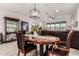 Inviting dining room with modern chandelier and a view into the living room at 13384 W Red Range Way, Peoria, AZ 85383
