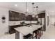 Modern kitchen featuring stainless steel appliances, dark cabinets, and a spacious granite island at 13384 W Red Range Way, Peoria, AZ 85383