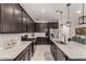 Stylish kitchen featuring dark cabinetry, granite countertops, stainless steel appliances, and ample counter space at 13384 W Red Range Way, Peoria, AZ 85383
