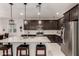 Well-appointed kitchen featuring dark wood cabinetry, a granite island with seating, and stainless steel appliances at 13384 W Red Range Way, Peoria, AZ 85383