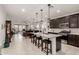 Open kitchen showcasing a large granite island, dark wood cabinets, and views of the living and dining areas at 13384 W Red Range Way, Peoria, AZ 85383