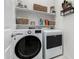 Bright laundry room featuring a modern washer and dryer, complemented by neatly arranged shelves and decorative accents at 13384 W Red Range Way, Peoria, AZ 85383