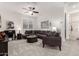 Bright living room with cozy seating, contemporary decor, plush carpet, and a ceiling fan at 13384 W Red Range Way, Peoria, AZ 85383