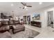 Comfortable living room featuring a brown leather sofa and fireplace, with an open view to the kitchen at 13384 W Red Range Way, Peoria, AZ 85383