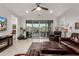 Bright living room featuring sliding glass doors, tile flooring, and comfortable leather seating at 13384 W Red Range Way, Peoria, AZ 85383