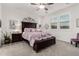 This inviting main bedroom features a dark wood bed frame, with light purple bedding and matching nightstands at 13384 W Red Range Way, Peoria, AZ 85383