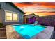 Modern pool area with clean lines, decorative foliage, and vibrant ambient lighting, creating a serene oasis at 13384 W Red Range Way, Peoria, AZ 85383
