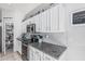 Well-lit kitchen featuring white cabinets, granite countertops, stainless steel appliances, and a pantry at 1508 S Danyell Pl, Chandler, AZ 85286