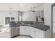 Kitchen with white cabinetry, granite countertops, and stainless-steel appliances, adjacent to living area at 1508 S Danyell Pl, Chandler, AZ 85286