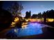The pool provides a calming nighttime ambiance with rock features and waterfall, illuminated by landscape lighting at 1508 S Danyell Pl, Chandler, AZ 85286