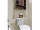 Bright bathroom featuring a white toilet and dark wood shelving for storage and decorative touch at 1588 E Sweet Citrus Dr, Queen Creek, AZ 85140
