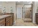 Bathroom featuring dark wood cabinets, earth-toned tile flooring and glass-enclosed shower at 1588 E Sweet Citrus Dr, Queen Creek, AZ 85140