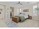 Bright bedroom with large windows, shutters, ceiling fan, and neutral carpet flooring at 1588 E Sweet Citrus Dr, Queen Creek, AZ 85140