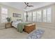 Bright bedroom with large windows, shutters, ceiling fan, and neutral carpet flooring at 1588 E Sweet Citrus Dr, Queen Creek, AZ 85140