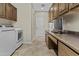 Laundry room with wood cabinets, counter space, and modern washer and dryer units at 1588 E Sweet Citrus Dr, Queen Creek, AZ 85140