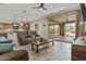 Open concept living room with kitchen view, sliding doors to patio, and modern furnishings at 1588 E Sweet Citrus Dr, Queen Creek, AZ 85140