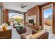 Inviting covered patio with stylish furniture, ceiling fan, and cozy fireplace at 1588 E Sweet Citrus Dr, Queen Creek, AZ 85140