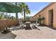 Charming backyard patio with brick pavers, outdoor seating, gas fire pit, palm trees, and vibrant desert landscaping at 1588 E Sweet Citrus Dr, Queen Creek, AZ 85140