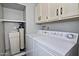 Bright laundry area features modern appliances, storage cabinets, and a water filtration system at 17289 E Kirk Ln, Fountain Hills, AZ 85268