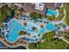 Aerial view of the community pool area featuring swimming pools, splash pads, lounge chairs, and beautifully landscaped grounds at 17514 W Desert Sage Dr, Goodyear, AZ 85338