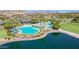 Aerial view of the community pool, splashpad, and lake offering various recreational options at 17514 W Desert Sage Dr, Goodyear, AZ 85338