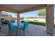 Relaxing outdoor patio area with a glass table, four chairs, and a landscaped backyard at 17514 W Desert Sage Dr, Goodyear, AZ 85338