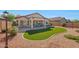 Secluded backyard with a covered patio, lush landscaping and a well-maintained artificial lawn at 17514 W Desert Sage Dr, Goodyear, AZ 85338