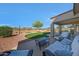 Beautiful backyard featuring a cozy seating area and a curved grass area with desert landscaping at 17514 W Desert Sage Dr, Goodyear, AZ 85338