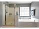 Bathroom with glass enclosed shower, soaking tub and towel rack with towels hanging at 17514 W Desert Sage Dr, Goodyear, AZ 85338