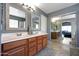 Double vanity in bath with decorative framed mirrors and mirrored closet at 17514 W Desert Sage Dr, Goodyear, AZ 85338