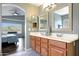 Bathroom featuring a double vanity with framed mirrors and a door into the bedroom at 17514 W Desert Sage Dr, Goodyear, AZ 85338