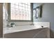 Bright bathroom showcasing a white soaking tub and a glass block window at 17514 W Desert Sage Dr, Goodyear, AZ 85338