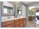 Bathroom featuring a double vanity with framed mirrors and a mirrored closet at 17514 W Desert Sage Dr, Goodyear, AZ 85338