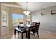 This dining room features a wood table, cushioned bench, and modern light fixture at 17514 W Desert Sage Dr, Goodyear, AZ 85338