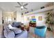 Cozy living room featuring a plush sofa, ceiling fan, and decorative shelving at 17514 W Desert Sage Dr, Goodyear, AZ 85338