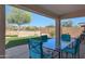 Relaxing covered patio area featuring a glass table, comfortable seating and artificial grass at 17514 W Desert Sage Dr, Goodyear, AZ 85338