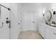 Bathroom featuring a dual vanity, round mirrors, and modern fixtures at 20332 W Sells Dr, Buckeye, AZ 85396
