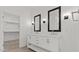 Elegant bathroom with a double sink vanity, stylish lighting, and a view into a spacious walk-in closet at 20332 W Sells Dr, Buckeye, AZ 85396