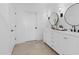 Bathroom featuring dual vanity, round mirrors, modern lighting, and neutral tones at 20332 W Sells Dr, Buckeye, AZ 85396