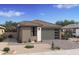 Charming single-story home featuring a modern garage door, desert landscaping, and a stone-accented facade at 20332 W Sells Dr, Buckeye, AZ 85396