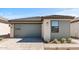 A modern home featuring a gray garage door, neutral stucco and siding and a brick driveway at 20332 W Sells Dr, Buckeye, AZ 85396