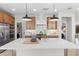 Bright kitchen with an island, stainless steel appliances, a white tile backsplash, and a view of the laundry room at 20332 W Sells Dr, Buckeye, AZ 85396