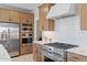 Modern kitchen featuring stainless steel appliances, wood cabinets and a stylish white tile backsplash at 20332 W Sells Dr, Buckeye, AZ 85396