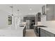 A modern kitchen with gray cabinets, stainless steel appliances, white countertops, and pendant lighting at 20332 W Sells Dr, Buckeye, AZ 85396