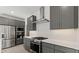 A modern kitchen with gray cabinets, stainless steel appliances, and white countertops at 20332 W Sells Dr, Buckeye, AZ 85396